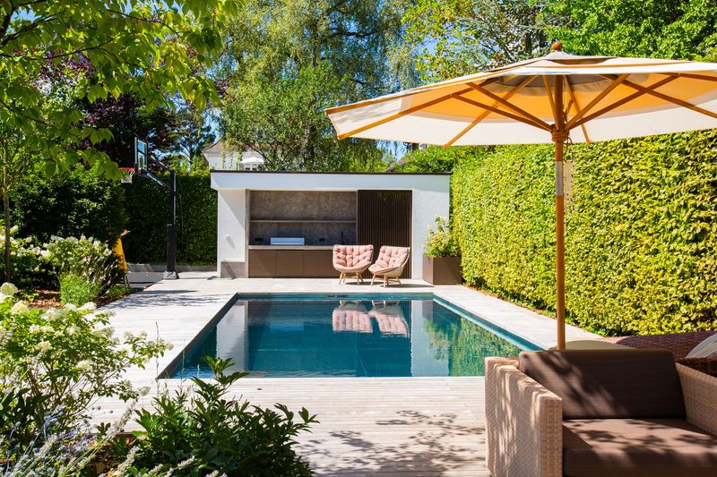 Edelstahl-Pool mit Sonnenschirm und Poolhaus