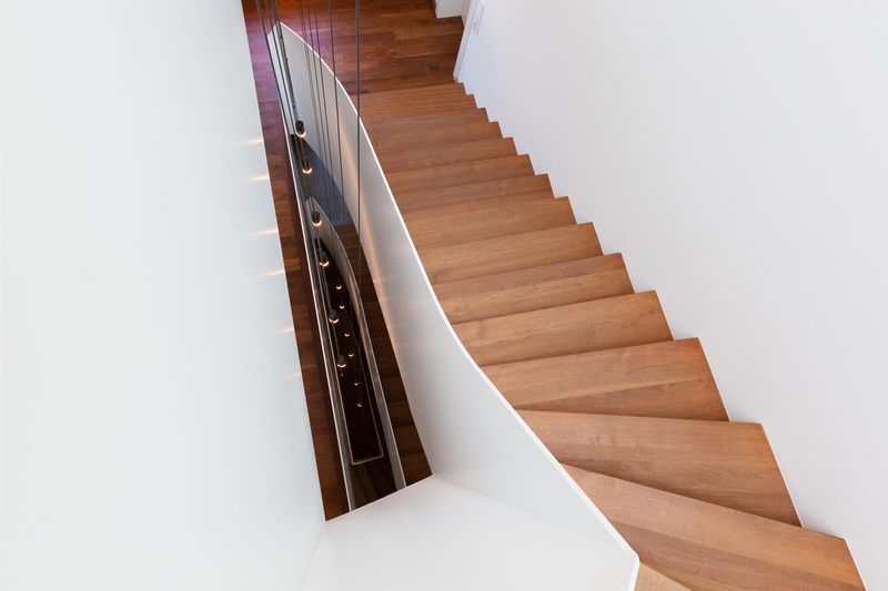 Treppe mit Holzstufen und Stahlgeländer von oben